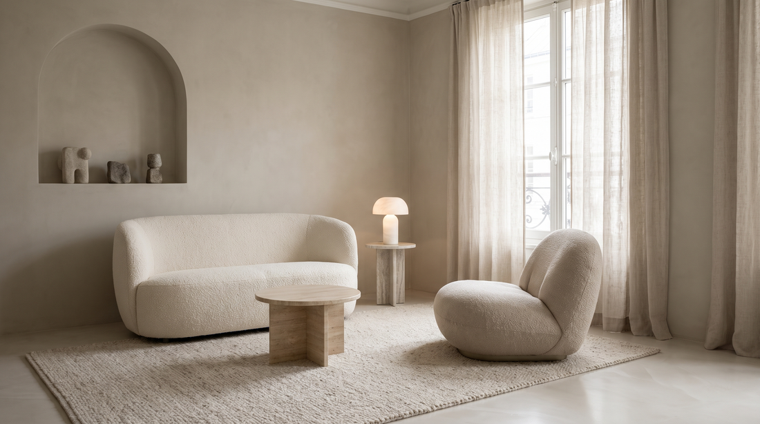 Small elegant sitting room with a compact curved sofa, boucle armchair and travertine table