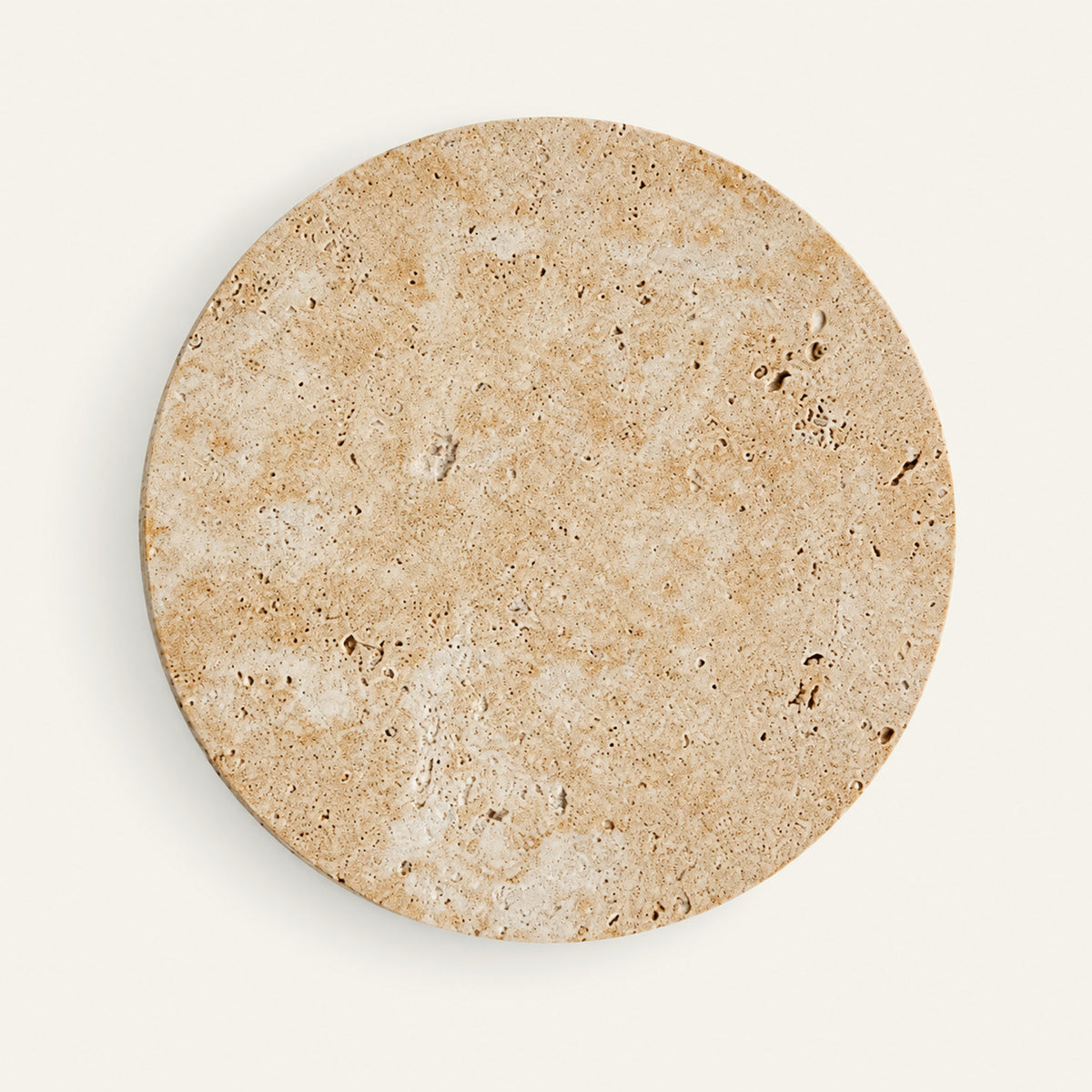 The Alba travertine wall light, a flat round stone disc