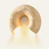 The Arco travertine wall light, a stone arch, lit