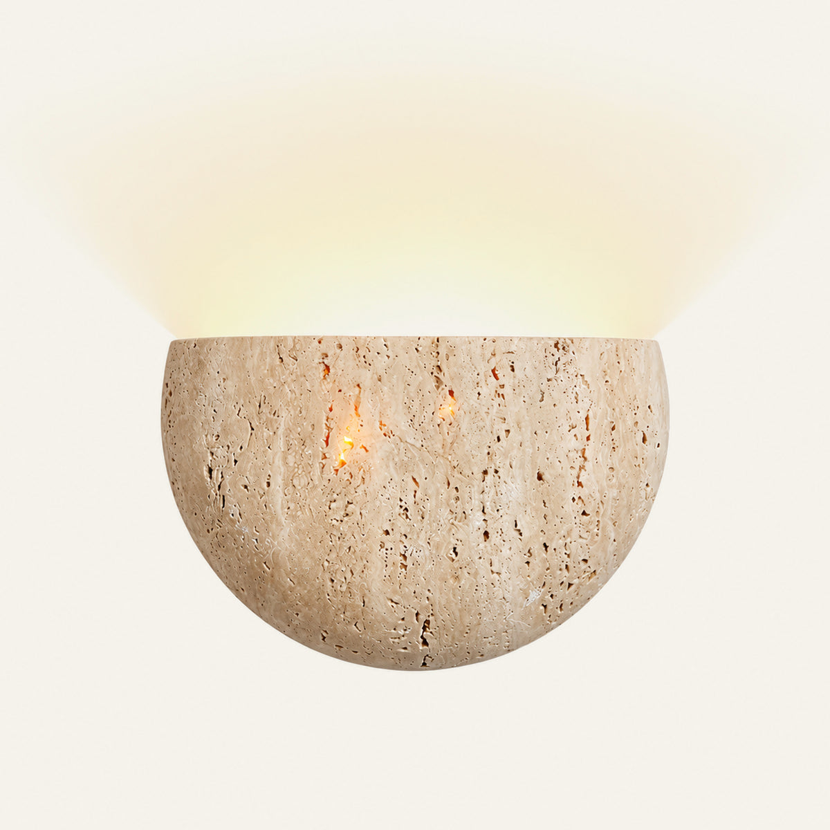 The Conchiglia travertine wall light, a half bowl of stone with light rising above