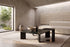 The Gaeta Marble Coffee Table Set in green marble, black oak and brass in a vaulted plaster room with a travertine slab