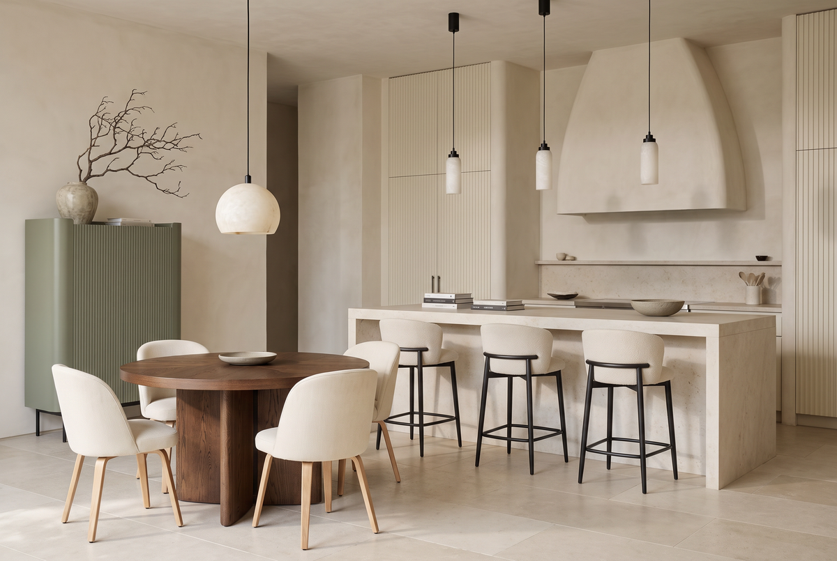 The Kitchen Table, a walnut round table and bar stools at a stone island with a sage fluted highboard
