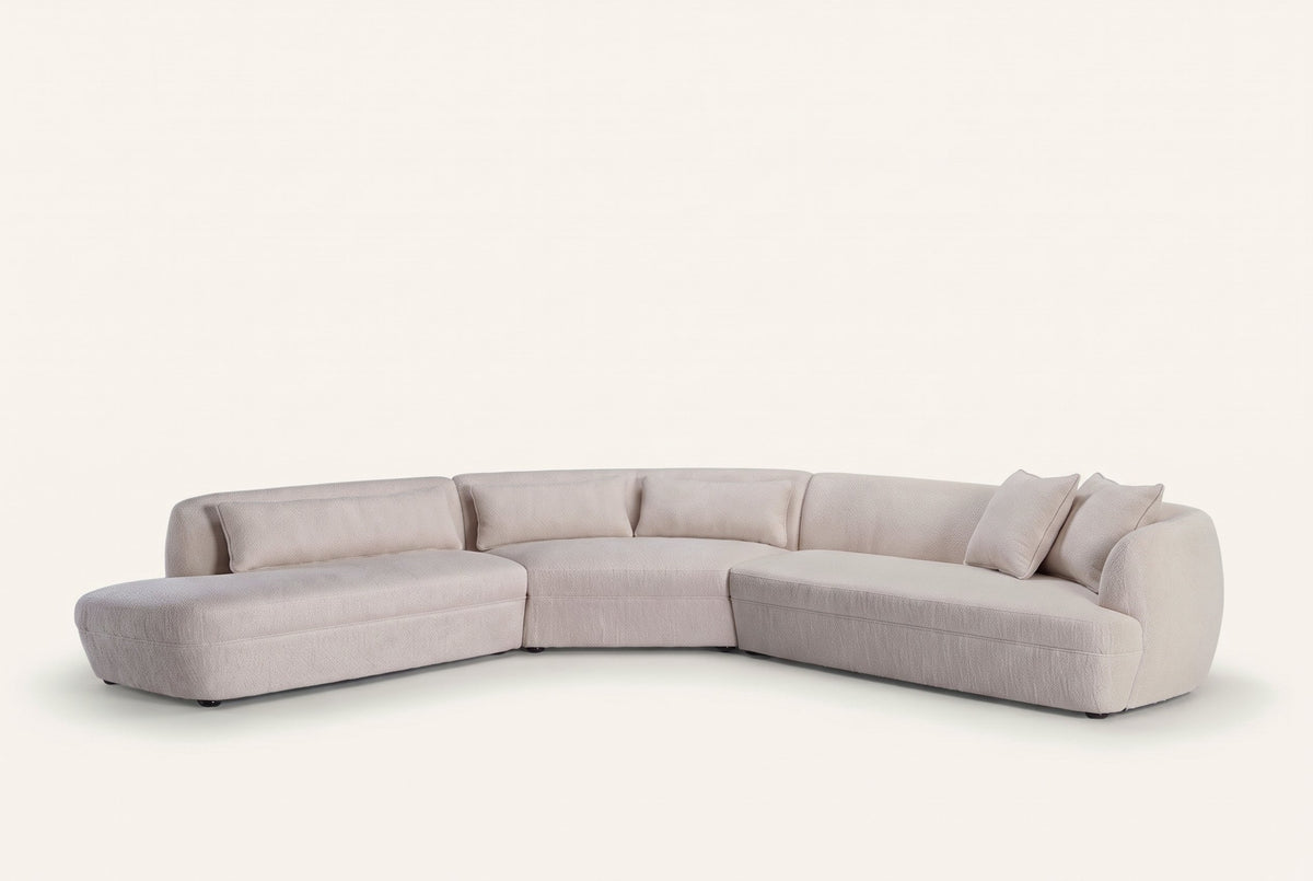 The Amalfi Curved Corner Sofa in cream boucle with matching cushions, studio view