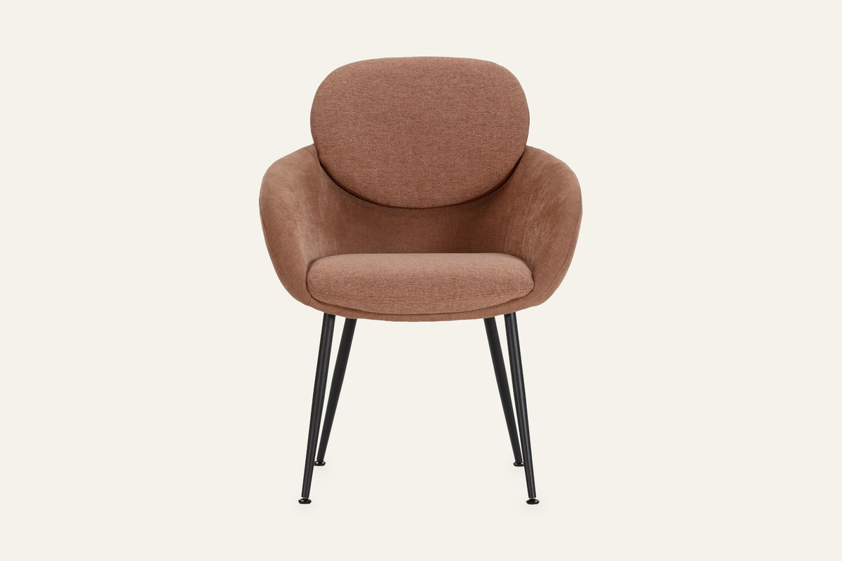 The Arona Armchair in coral, upholstered tub armchair on slim black legs, studio view