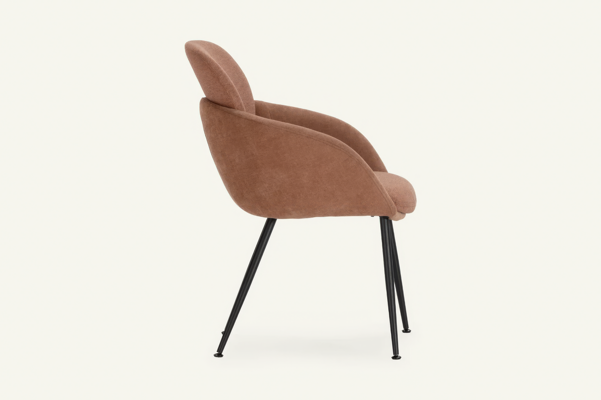 The Arona Armchair in coral, upholstered tub armchair on slim black legs, studio view