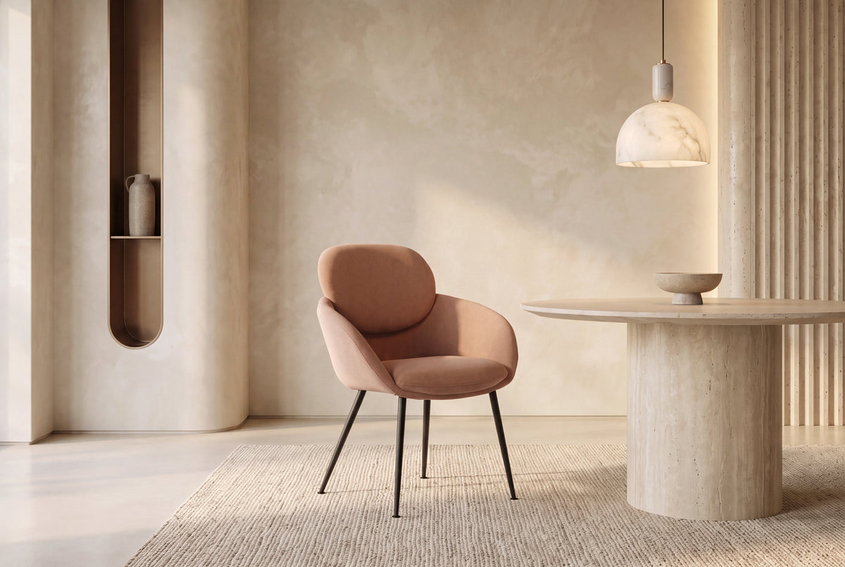 The Arona Armchair in coral, upholstered tub armchair on slim black legs, styled in a room