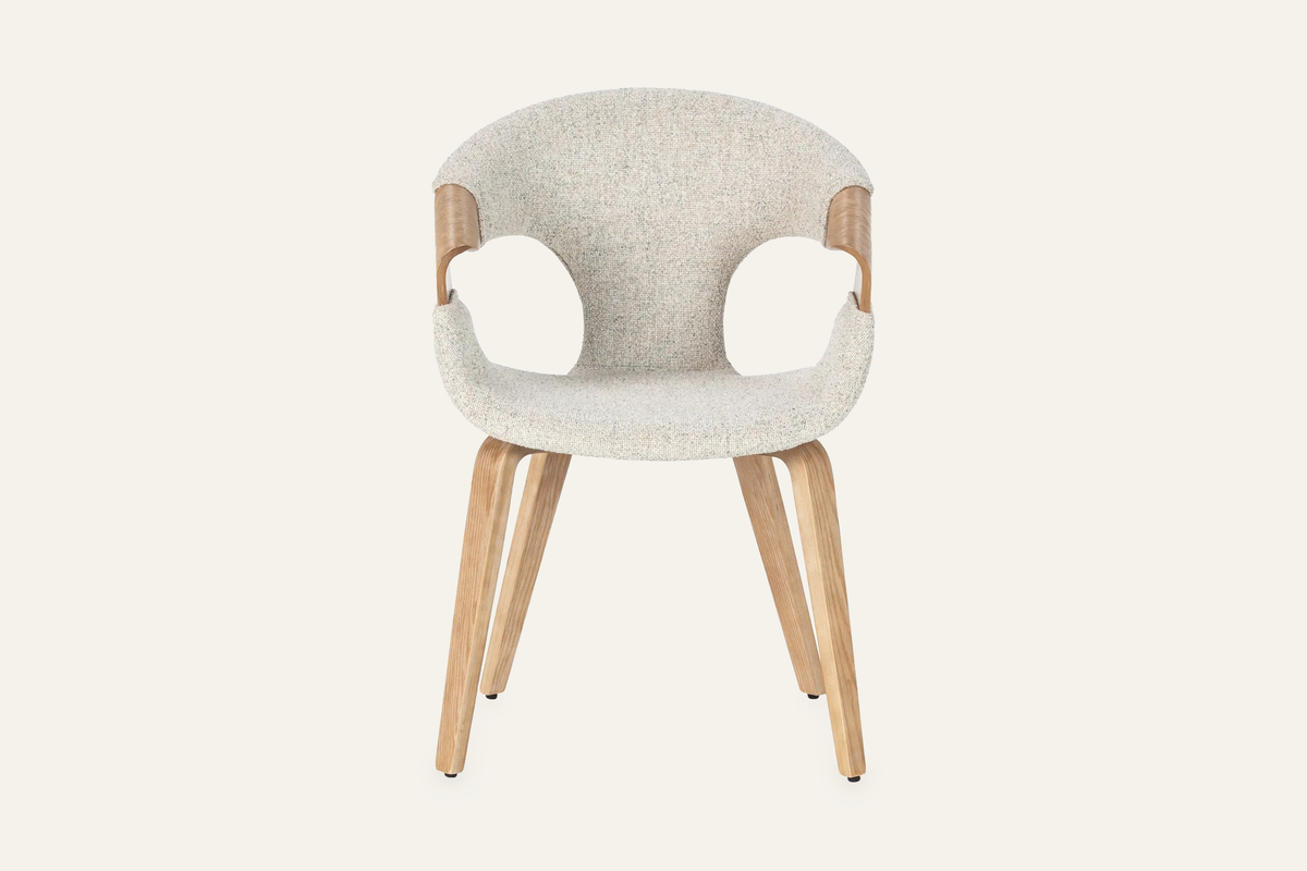 The Ascoli Dining Chair, ivory dining chair with an open curved oak back, studio view