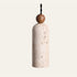 The Bacchetta travertine pendant light, a slim cream stone cylinder with a round wood bead on a black twisted cable