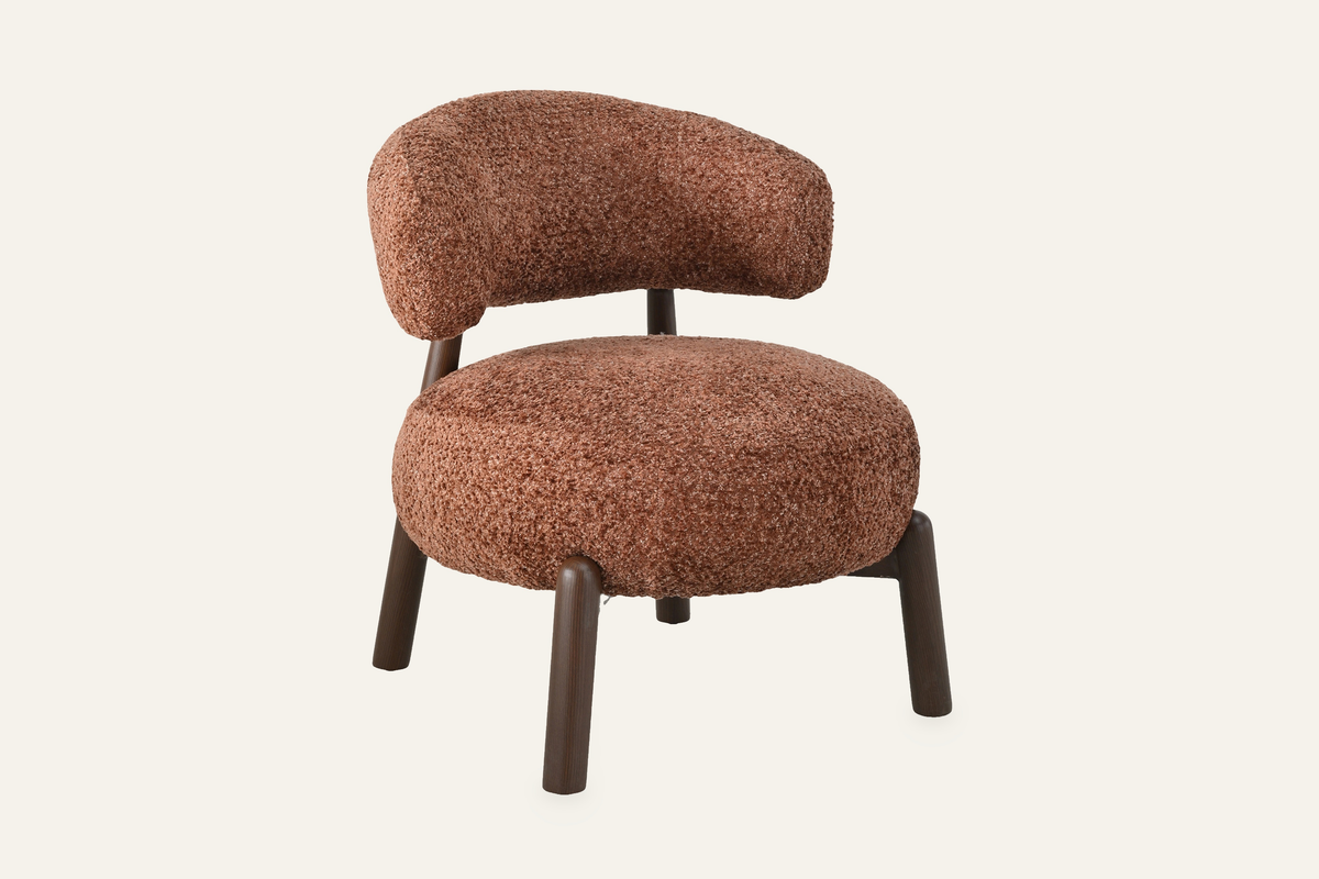 The Bardolino Armchair in terracotta, curved-back armchair in textured fabric, studio view
