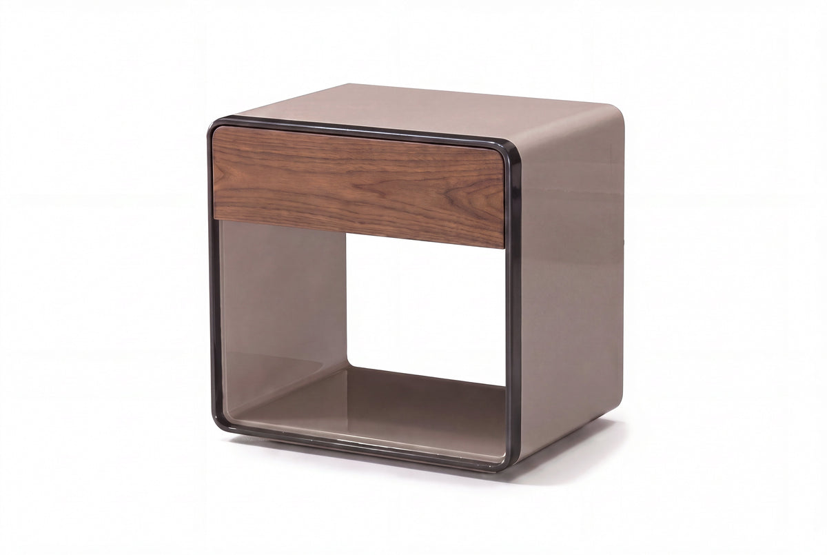 The Bari Bedside Table in taupe lacquer with a walnut drawer front and dark gunmetal trim, studio view