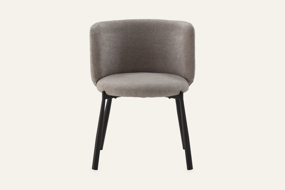 The Bormio Dining Armchair in grey, upholstered dining armchair on black metal legs, studio view