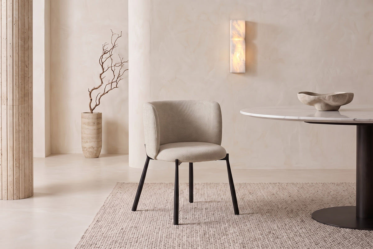 The Bormio Dining Armchair in oatmeal, upholstered dining armchair on black metal legs, styled in a room