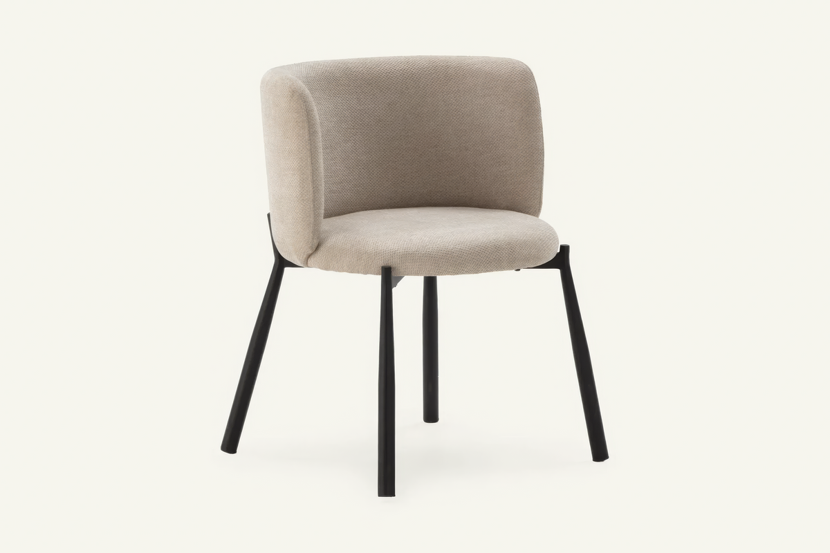 The Bormio Dining Armchair in oatmeal, upholstered dining armchair on black metal legs, studio view
