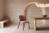 The Bormio Dining Chair in coral, upholstered dining chair on black metal legs, styled in a room
