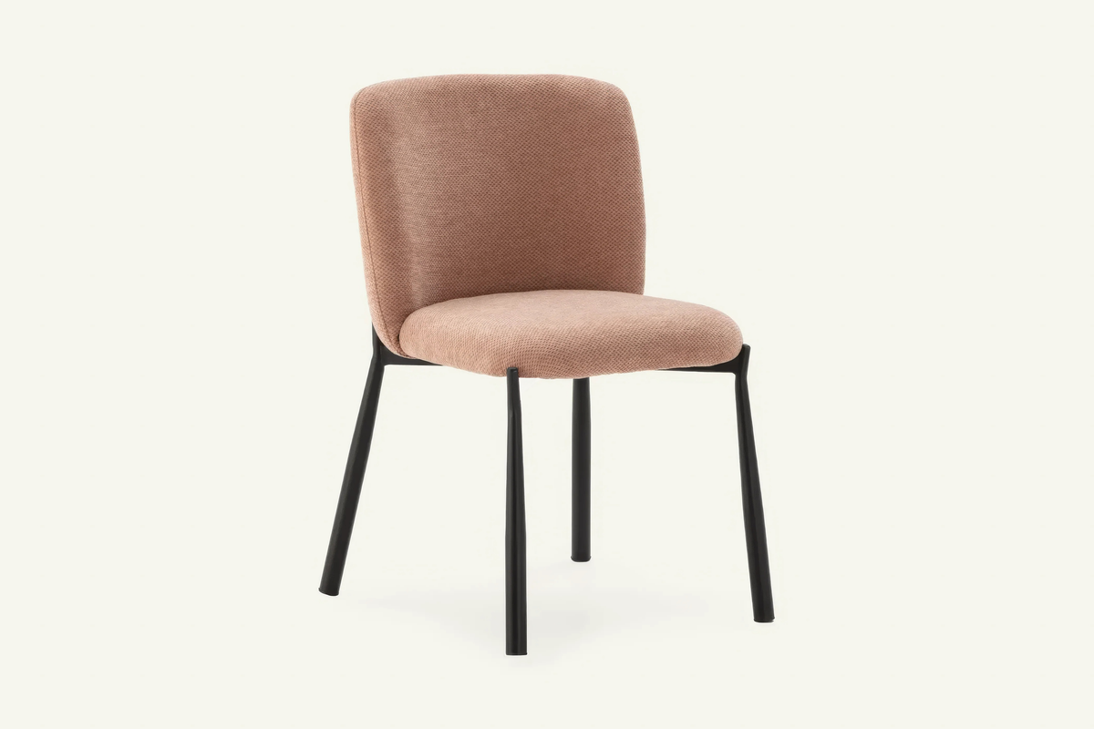 The Bormio Dining Chair in coral, upholstered dining chair on black metal legs, studio view