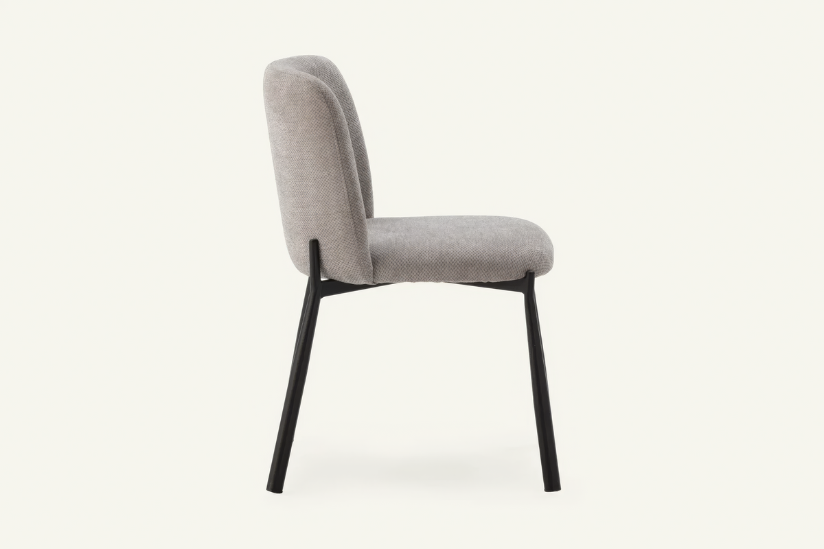 The Bormio Dining Chair in grey, upholstered dining chair on black metal legs, studio view
