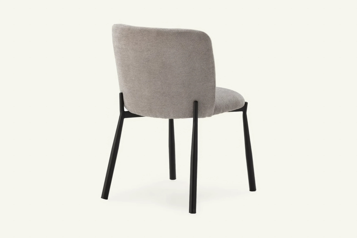 The Bormio Dining Chair in grey, upholstered dining chair on black metal legs, studio view