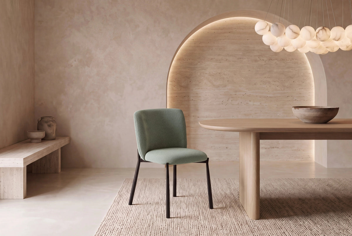 The Bormio Dining Chair in sage, upholstered dining chair on black metal legs, styled in a room