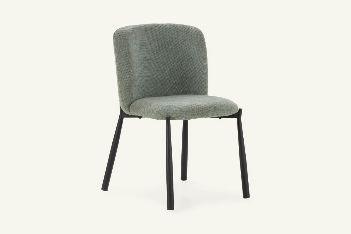The Bormio Dining Chair in sage, upholstered dining chair on black metal legs, studio view