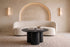 The Bosa Coffee Table in black, round coffee table on a clustered column base, styled in a room