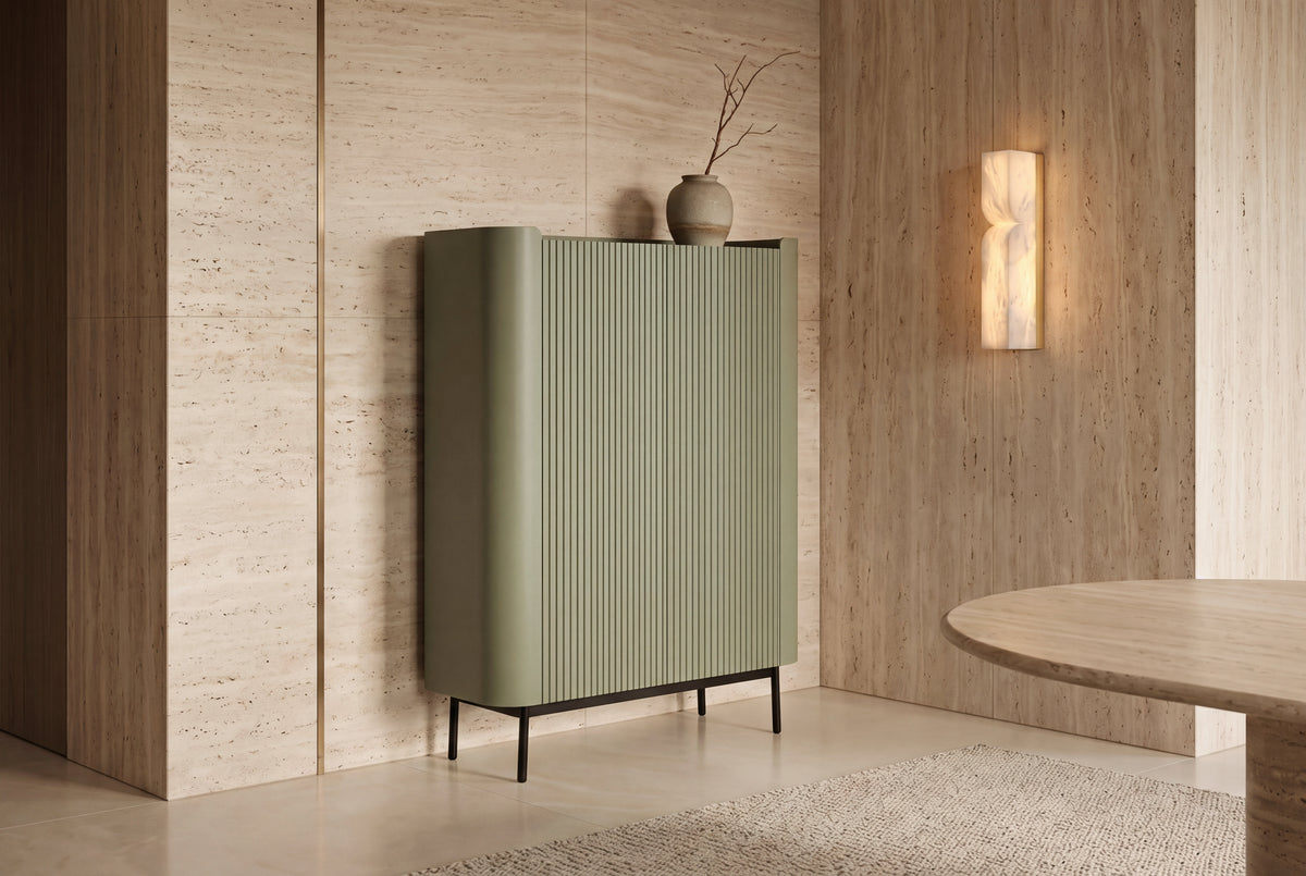 The Camogli Fluted Highboard in sage against a travertine wall beside an alabaster wall light