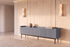 The Camogli Fluted TV Unit in blue against a travertine wall between two alabaster wall lights
