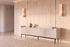 The Camogli Fluted TV Unit in cream against a travertine wall between two alabaster wall lights