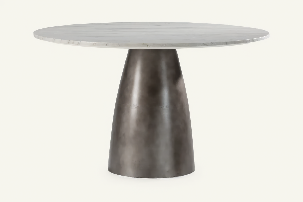 The Carrara Marble Round Dining Table, round white marble dining table on a dark pedestal, studio view