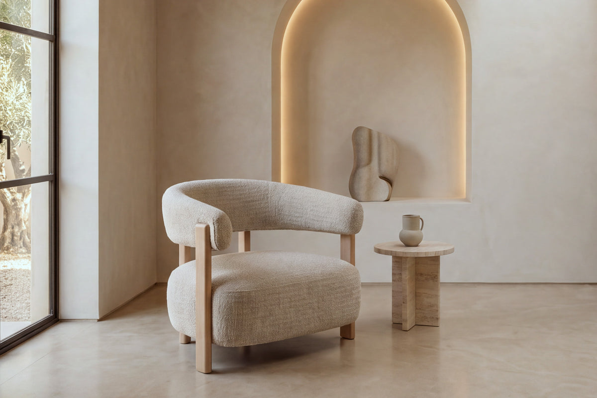 The Cetraro Armchair in beige boucle beside a lit arched plaster niche
