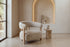 The Cetraro Armchair in beige boucle beside a lit arched plaster niche
