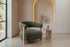 The Cetraro armchair in green boucle beside a travertine side table