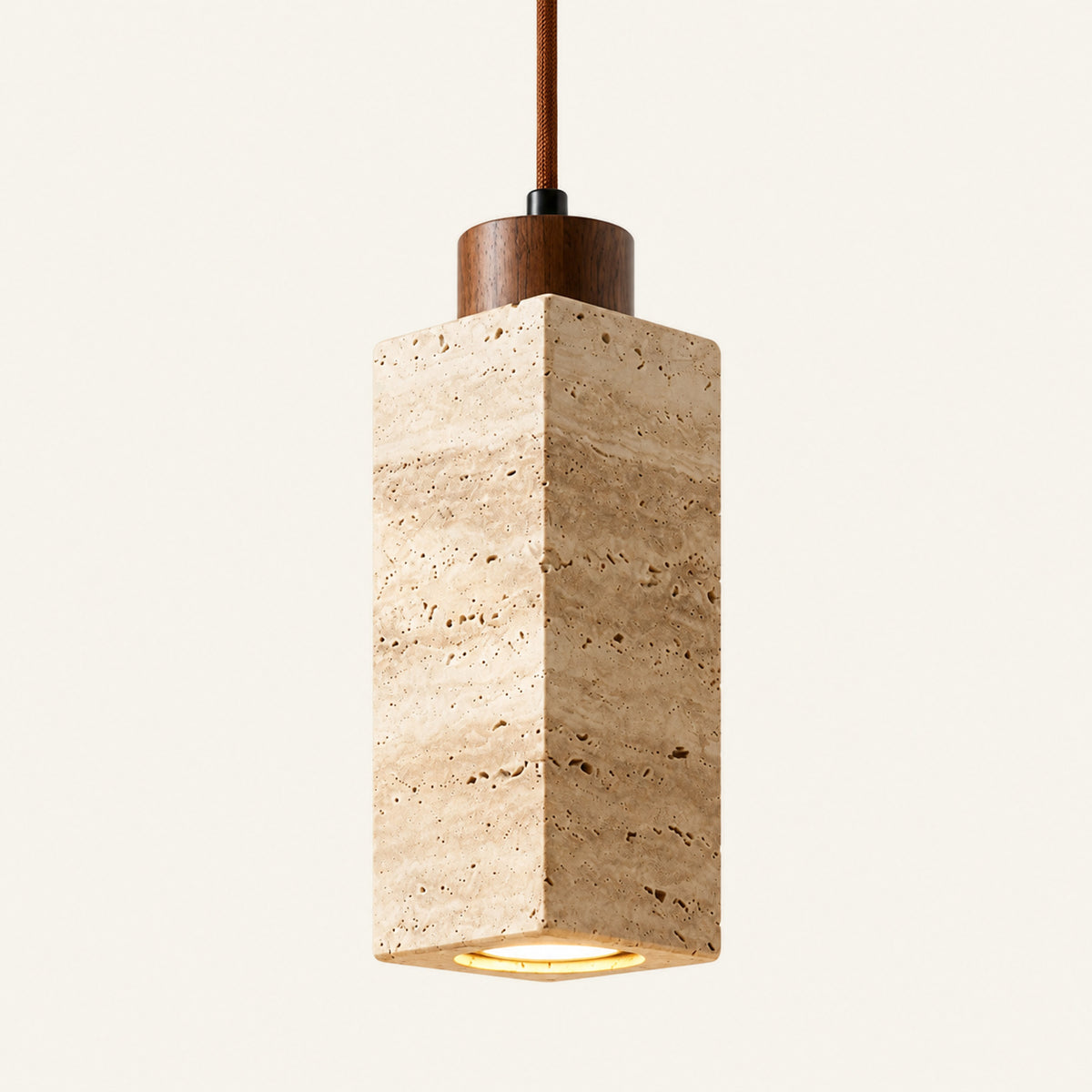The Colonnina travertine pendant light, a slim cream stone column with a wood cap on a brown cable, alternate view