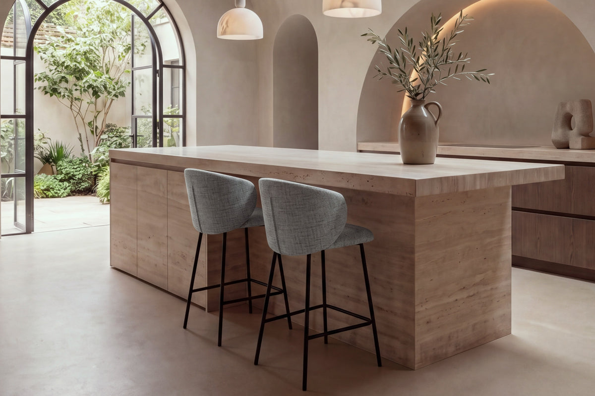Two Framura Counter Stools in grey at a travertine kitchen island under a vaulted plaster ceiling