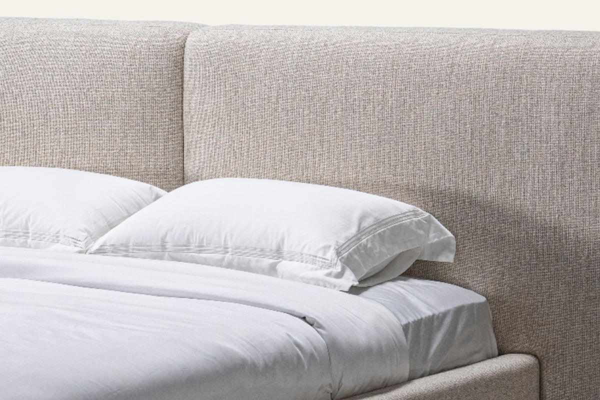 The Lecce Bed, close-up of the panelled headboard in light grey weave