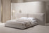 The Lecce Bed with a wide panelled headboard in a calm plaster bedroom
