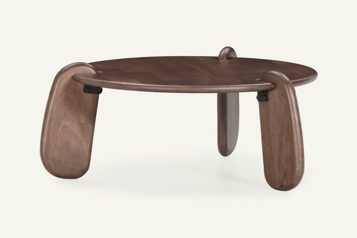 The Lipari Coffee Table in walnut, round mango wood coffee table with sculpted legs, studio view