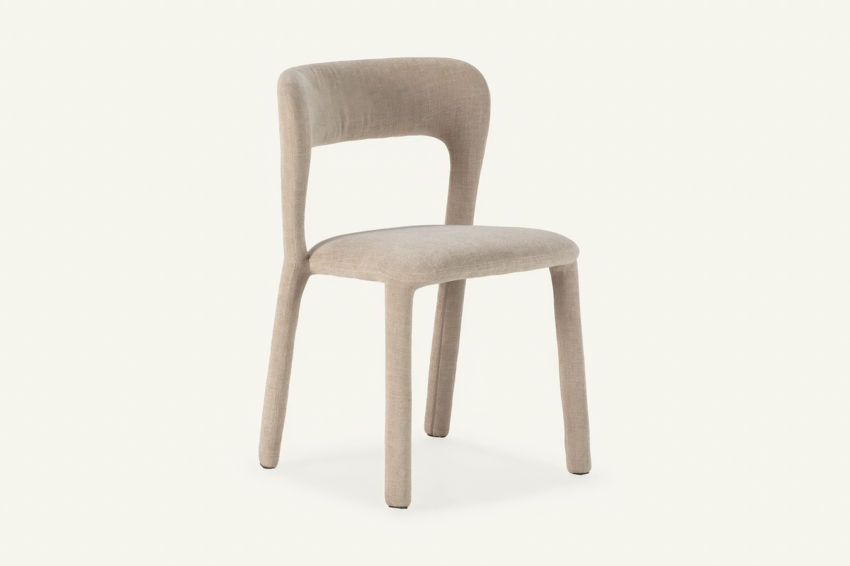 The Lucera Dining Chair in greige, sculptural upholstered dining chair with an open curved back, studio view