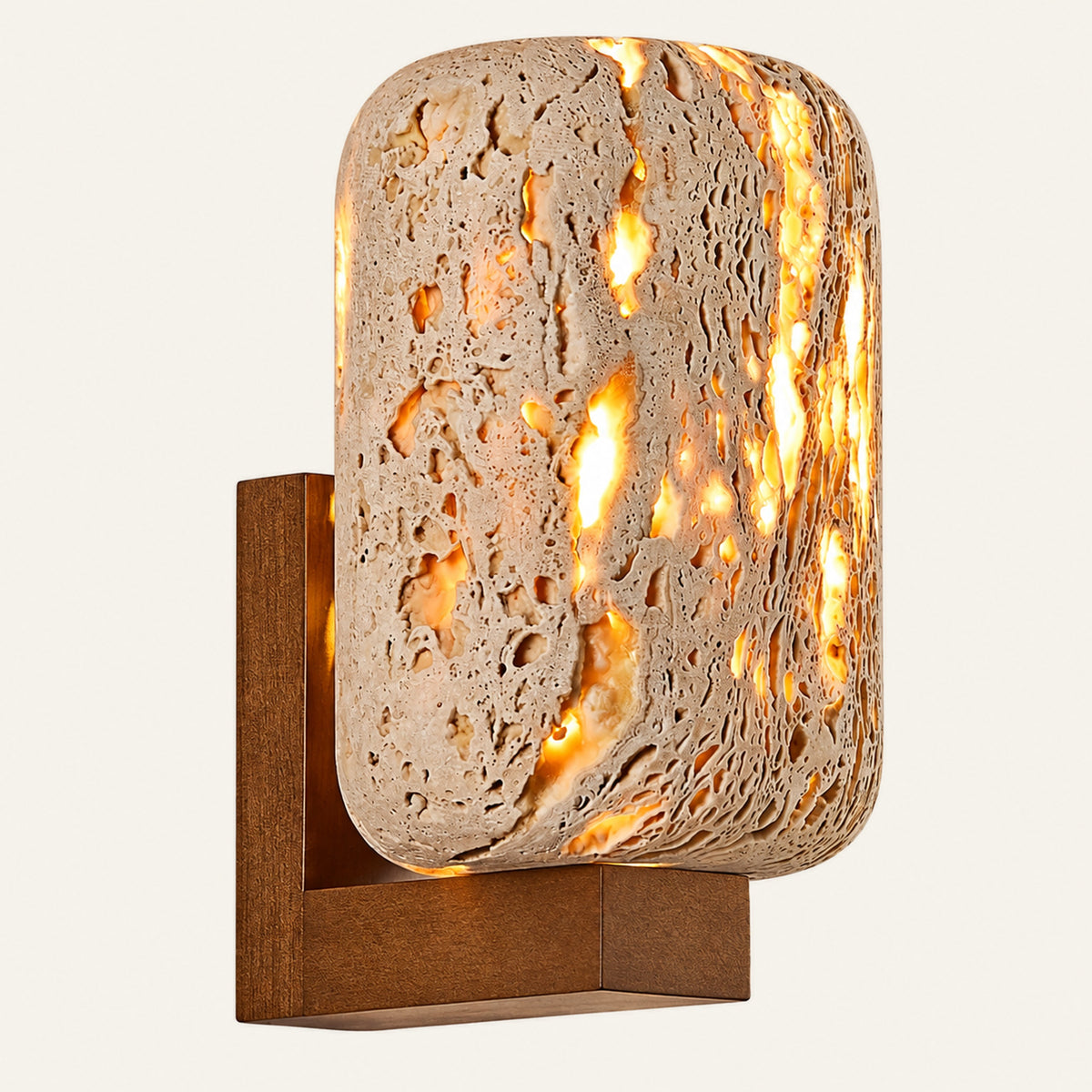 The Lucerna travertine wall light, a rounded block of pierced travertine on a wood wall bracket, glowing through its pores