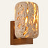 The Lucerna travertine wall light, a rounded block of pierced travertine on a wood wall bracket, glowing through its pores