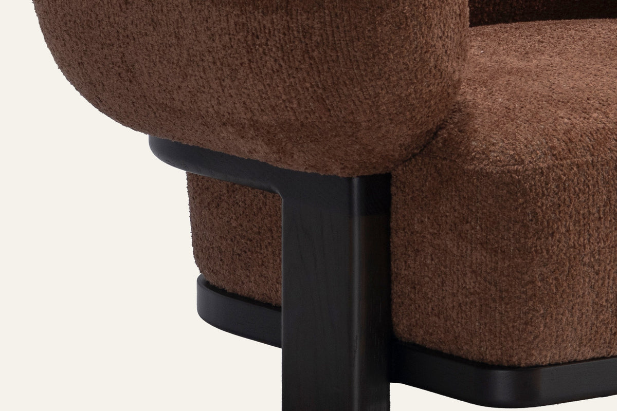 The Matera Accent Chair, close-up of the cocoa boucle arm and black wood frame