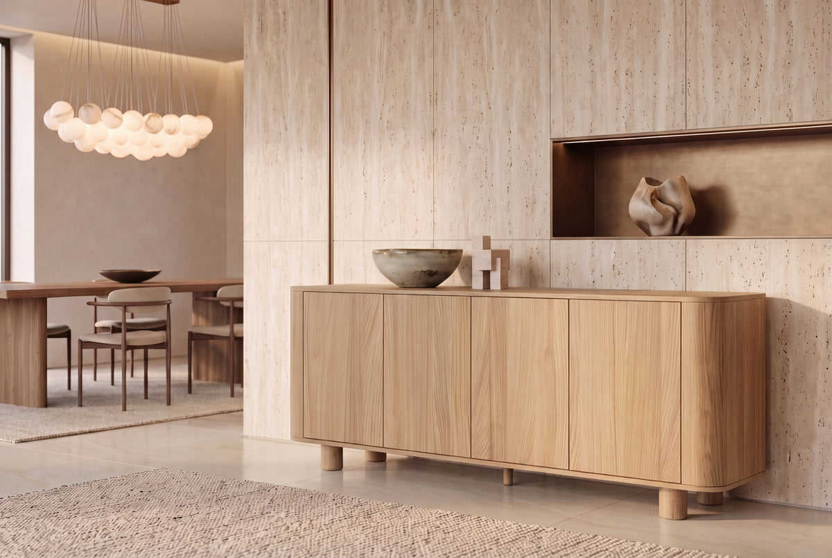 The Menton Sideboard in oak in a travertine dining room beneath an alabaster sphere chandelier