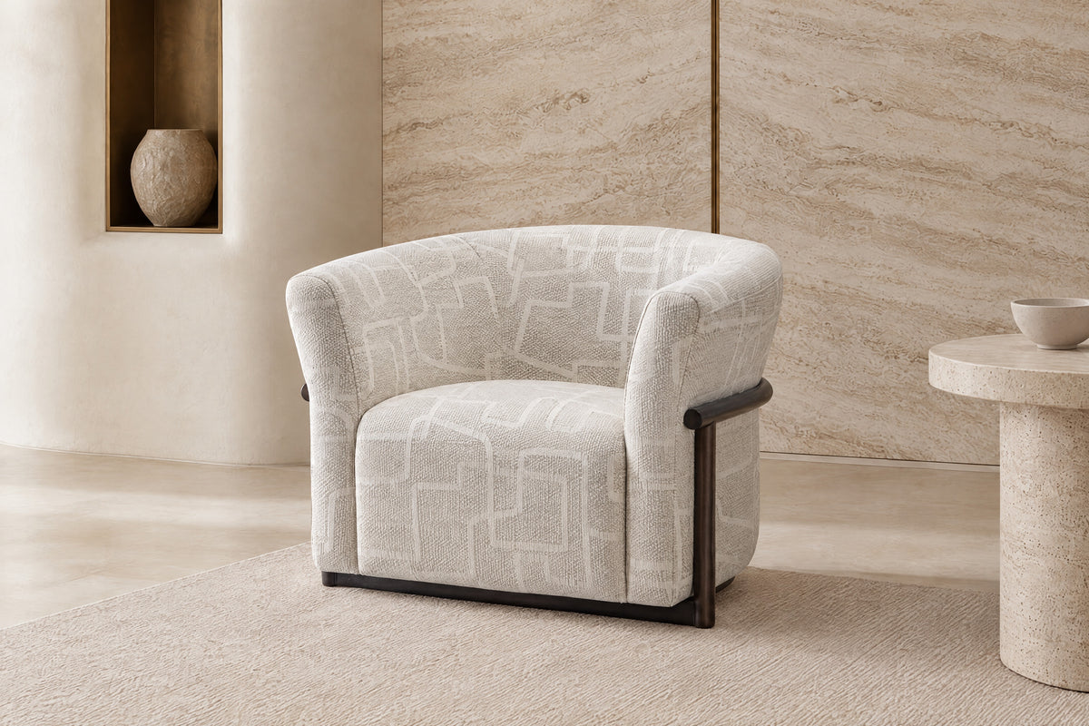 The Modica Armchair in cream geometric weave in a travertine-lined room