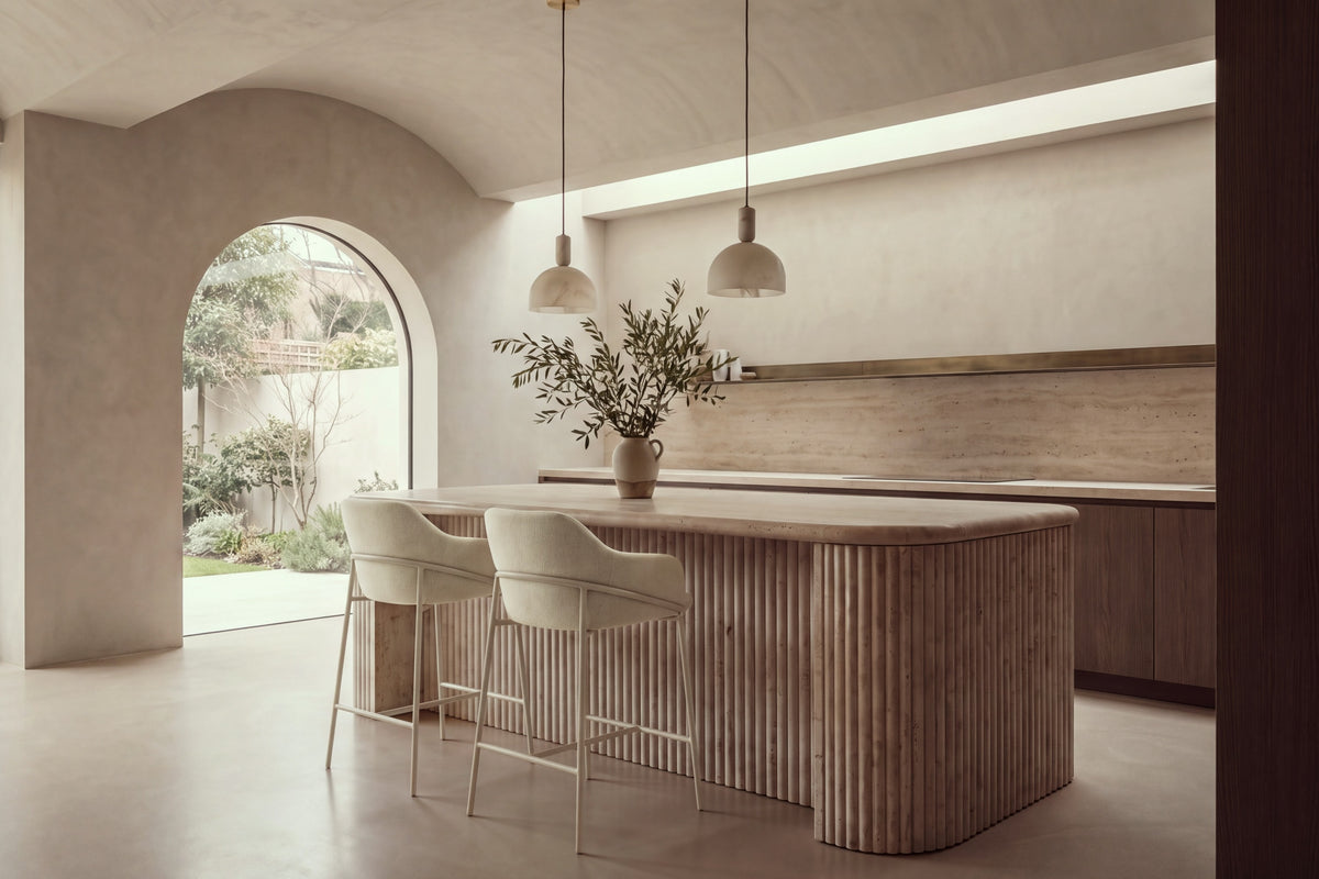 Two Moneglia Counter Stools in beige with beige legs at a fluted travertine kitchen island