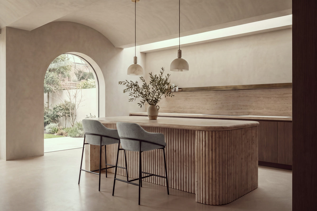 Two Moneglia Counter Stools in grey with black legs at a fluted travertine kitchen island