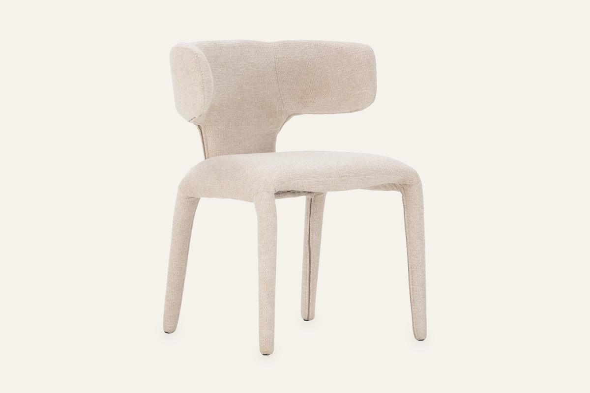 The Nemi Dining Chair in beige, fully upholstered curved dining chair, studio view