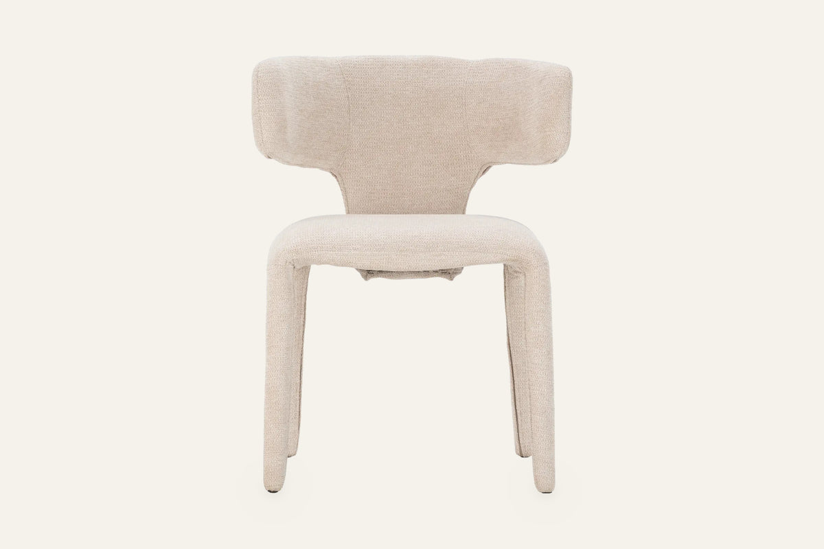 The Nemi Dining Chair in beige, fully upholstered curved dining chair, studio view