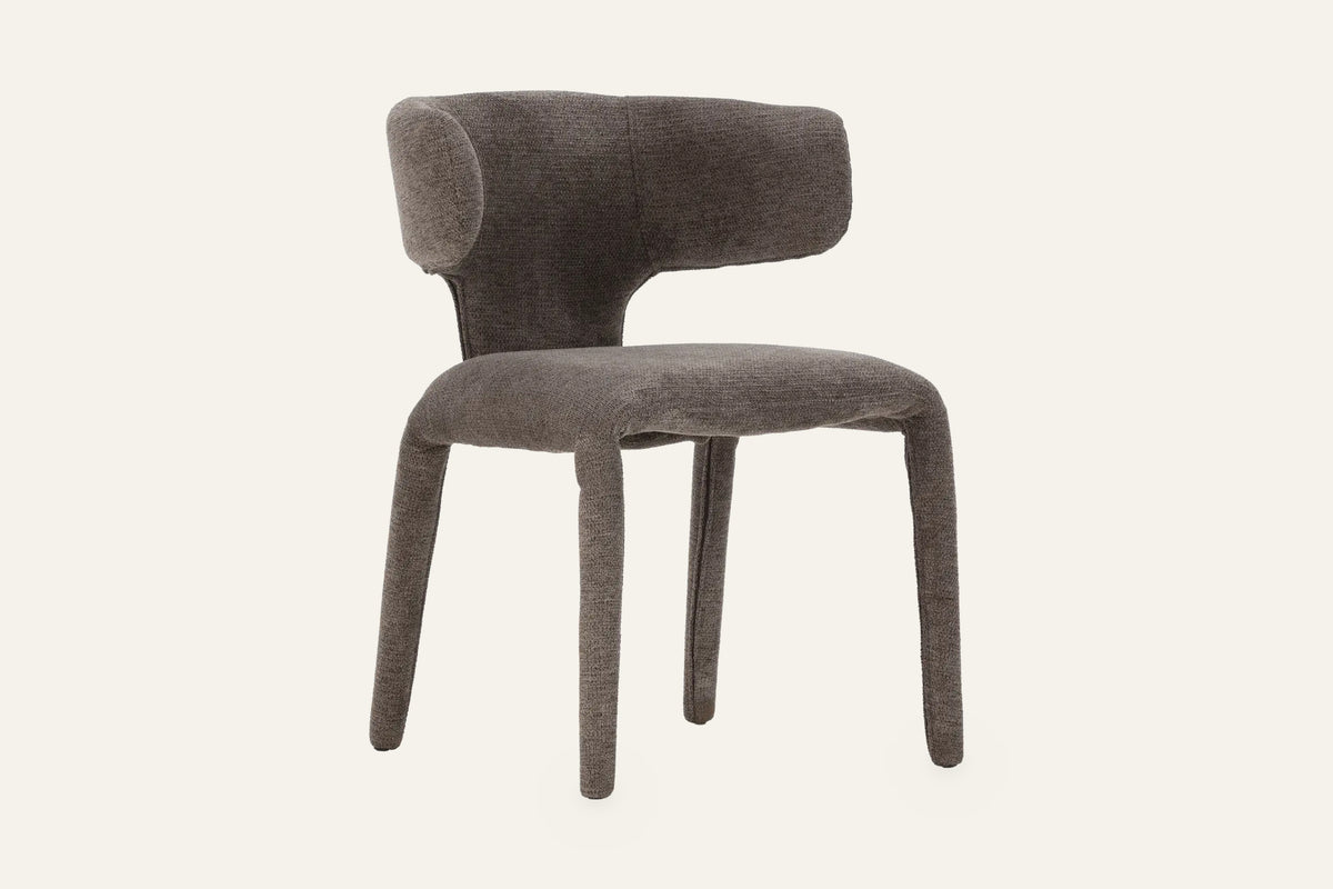 The Nemi Dining Chair in charcoal, fully upholstered curved dining chair, studio view
