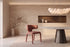 The Nemi Dining Chair in terracotta, fully upholstered curved dining chair, styled in a room