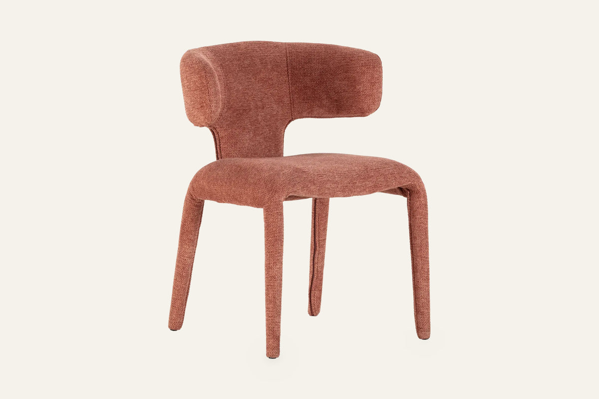 The Nemi Dining Chair in terracotta, fully upholstered curved dining chair, studio view