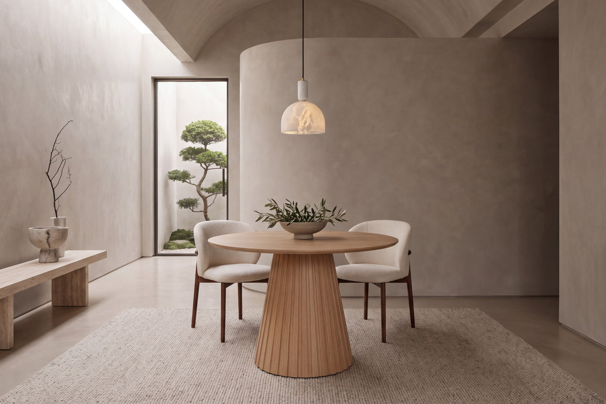 The Nervi Round Dining Table with Norcia chairs beneath a Cupola alabaster pendant in a barrel-vaulted plaster dining room